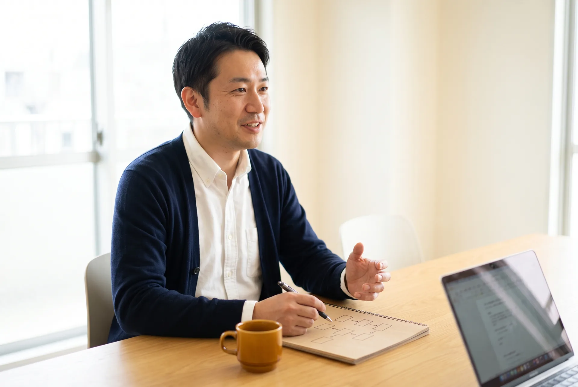 オンライン相談で、制作担当者がサイト構成をノートに書きながら説明している